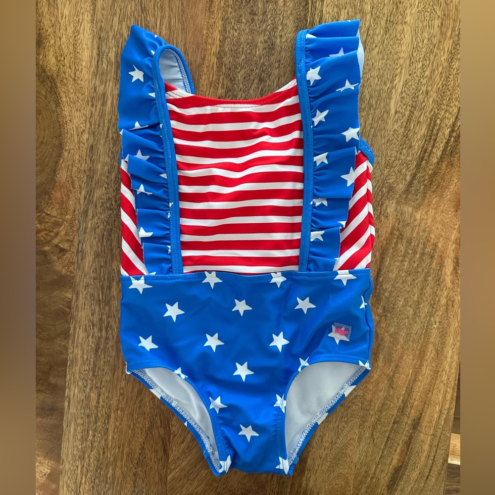 RuffleButts Toddler Girls UPF50+ Pinafore One
Piece - Shimmer Stars & Stripes